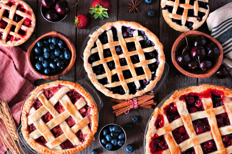 Variety of homemade fruit pies. Top view table scene over a rust