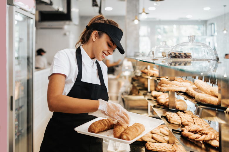 Beautiful young and happy female worker working in a modern bake