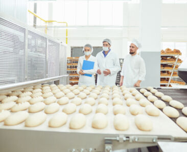 Technologist and baker inspect the bread production line at the bakery.