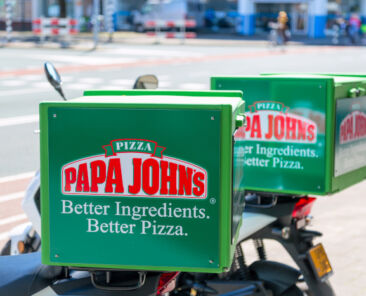 Amsterdam, Netherlands - May, 2018: A close-up of the Papa Johns Pizza logo on delivery bicycles outdoors. Papa John's Pizza is an American pizza restaurant company