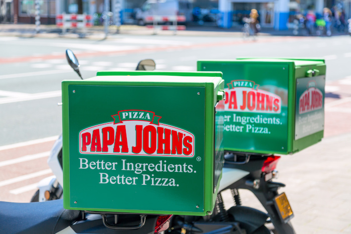 Amsterdam, Netherlands - May, 2018: A close-up of the Papa Johns Pizza logo on delivery bicycles outdoors. Papa John's Pizza is an American pizza restaurant company.